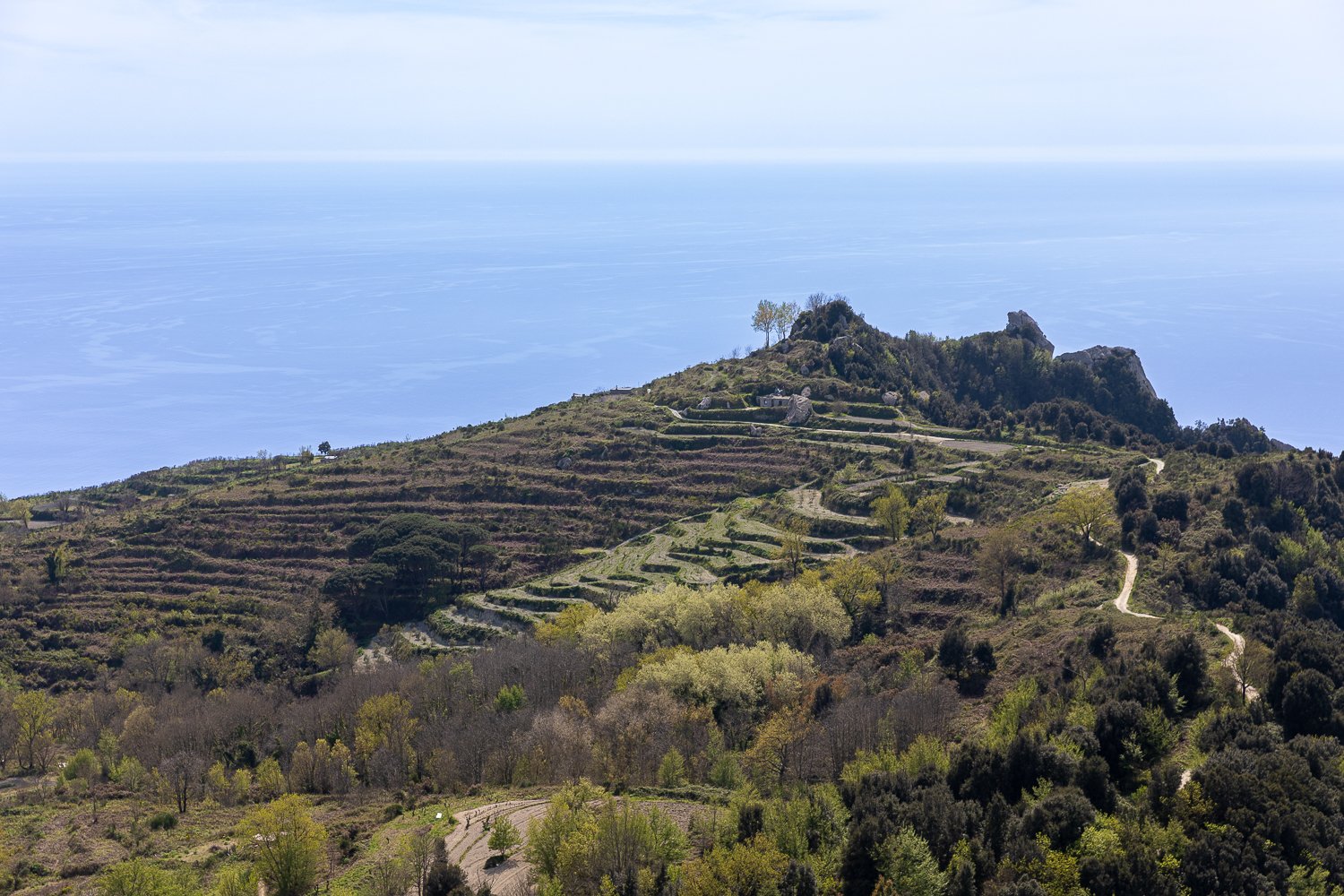 Beautiful view of Ischia hills against the blue waters of the ocean on the background