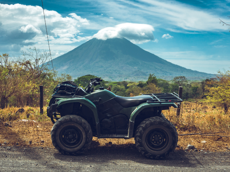 Black ATV with a volcano on the background. Riding an ATV is one of the awesome things to do in Ometepe.