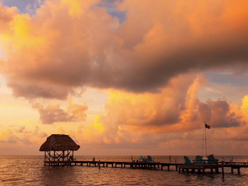 Sunset and a palapa on a dock in Belize