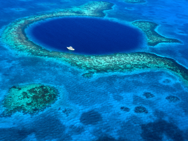 Aerial shot of the Blue Hole - one of the best places to visit while vacationing in Caye Caulker