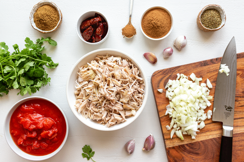 Ingredients for vegan jackfruit tinga include chipotle, tomatoes, garlic, adobo sauce, spices, and more.