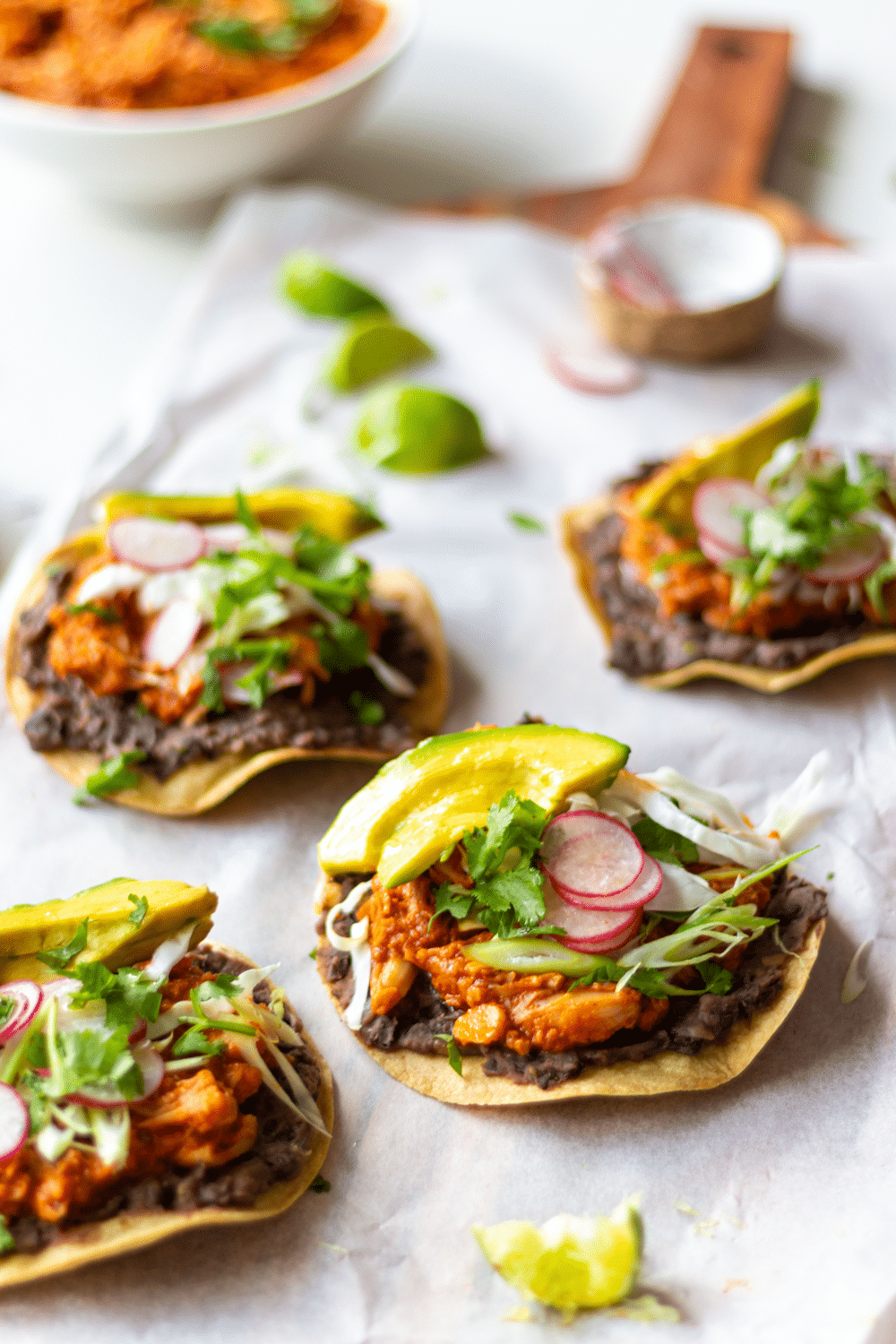 Jackfruit Tinga Tostadas make for an easy and delicious Mexican-inspired dinner! These tostadas are crispy, slathered with flavor-packed refried black beans, then topped with smoky, meaty pulled jackfruit. Quick, healthy, and flavor-packed, you'll love this Vegan Jackfruit Tinga in tostadas, tacos, and burritos!