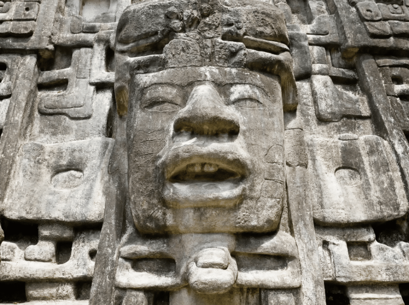 carved face on a Maya temple in Belize