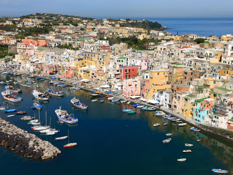 Colorful buildings and boats at Procida. Visiting this lesser-known island is one of the best things to do in Ischia, Italy.