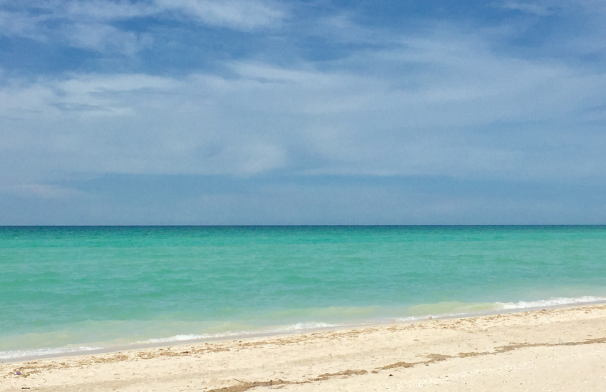Beautiful emerald waters and white-sand beach in Mexico. Relaxing by the beach is one of the amazing things to do in Sisal, Yucatan.
