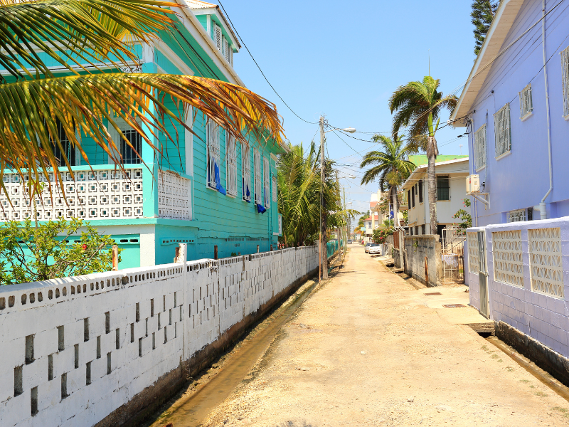 Quiet street lined with colorful houses in Belize. Make your Belize vacation unforgettable by following our Belize travel tips.