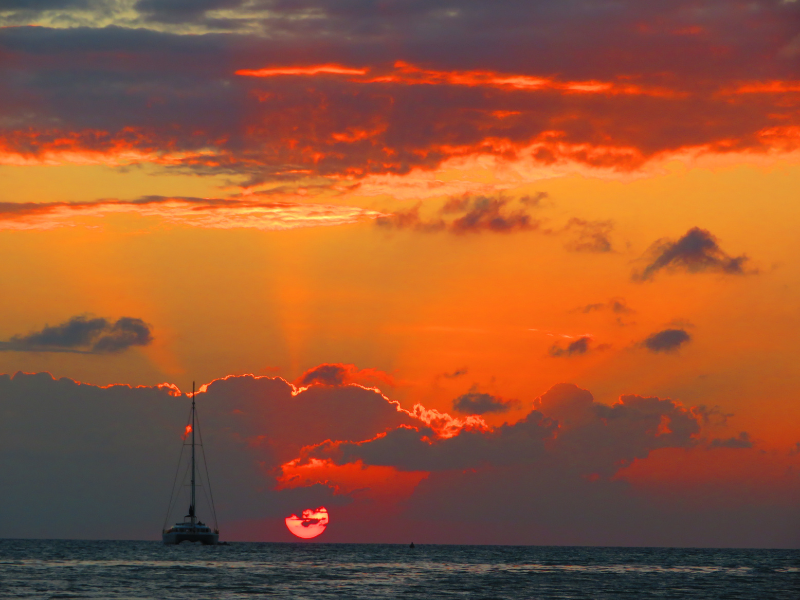Sunset and a sailboat in Caye Caulker - a sunset sail is one of the most fun things to do in Caye Caulker